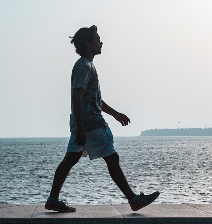 man-walking-near-body-of-water-crop